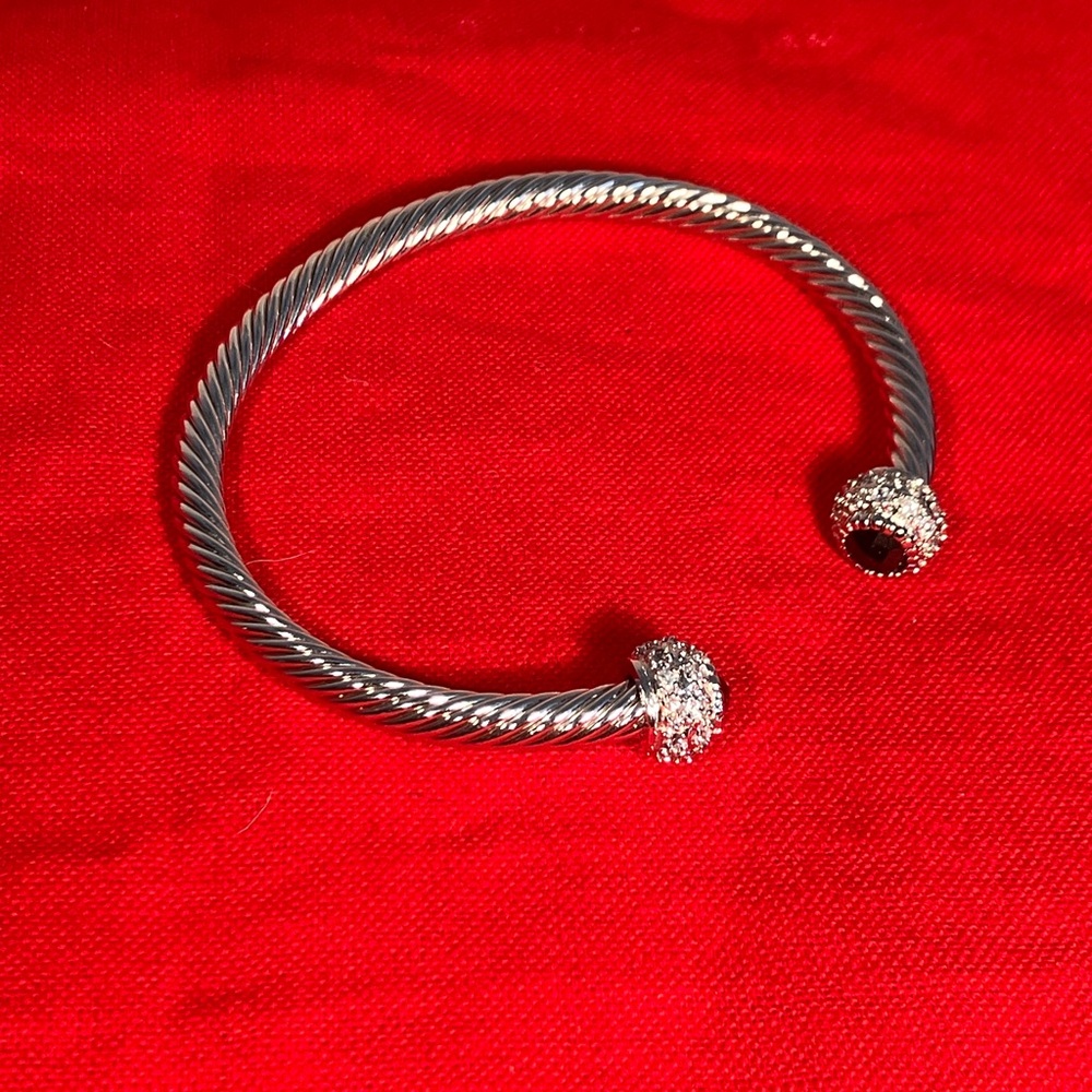 This cuff bracelet is inspired by a Yurman design. With clear and jet end caps.
